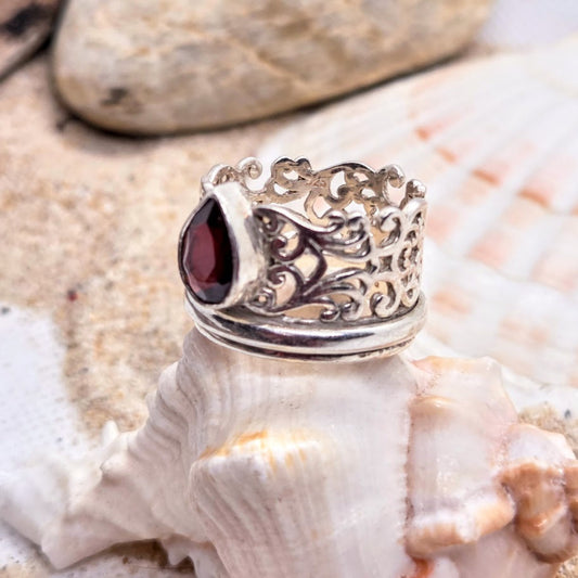 Silver ring with a red gemstone on a seashell