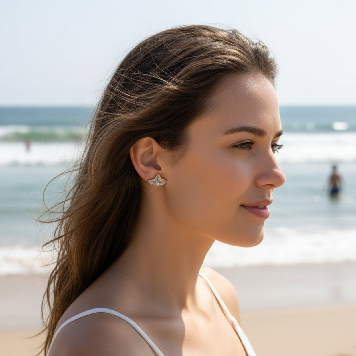 Woman wearing earrings with a beach background