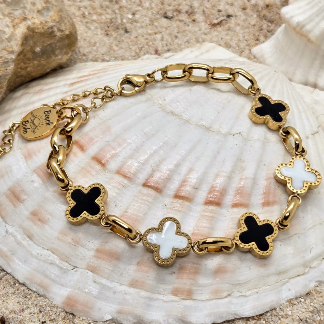 Gold bracelet with butterfly charms on a seashell