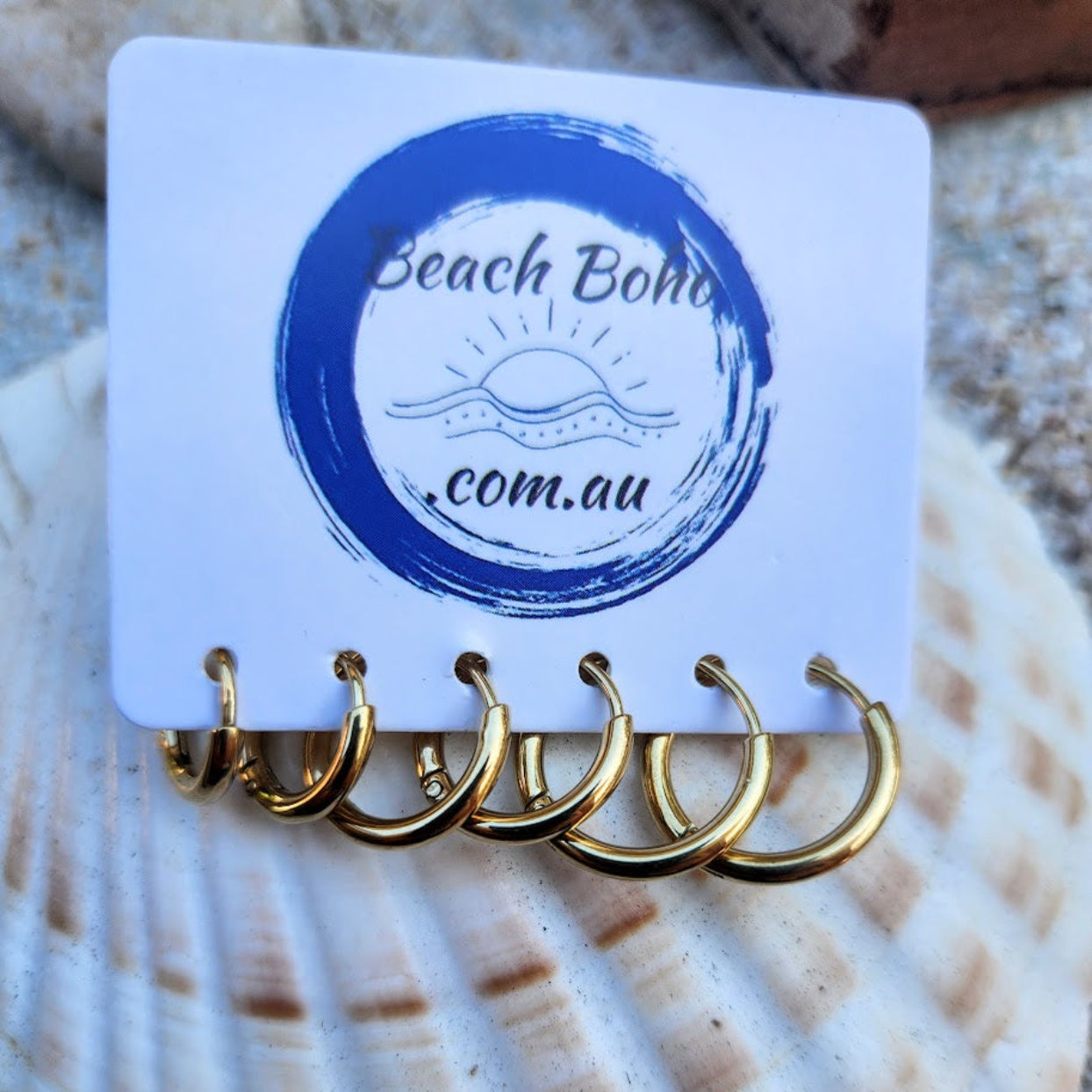 Set of gold hoop earrings on a 'Beach Boho' branded card with a shell background