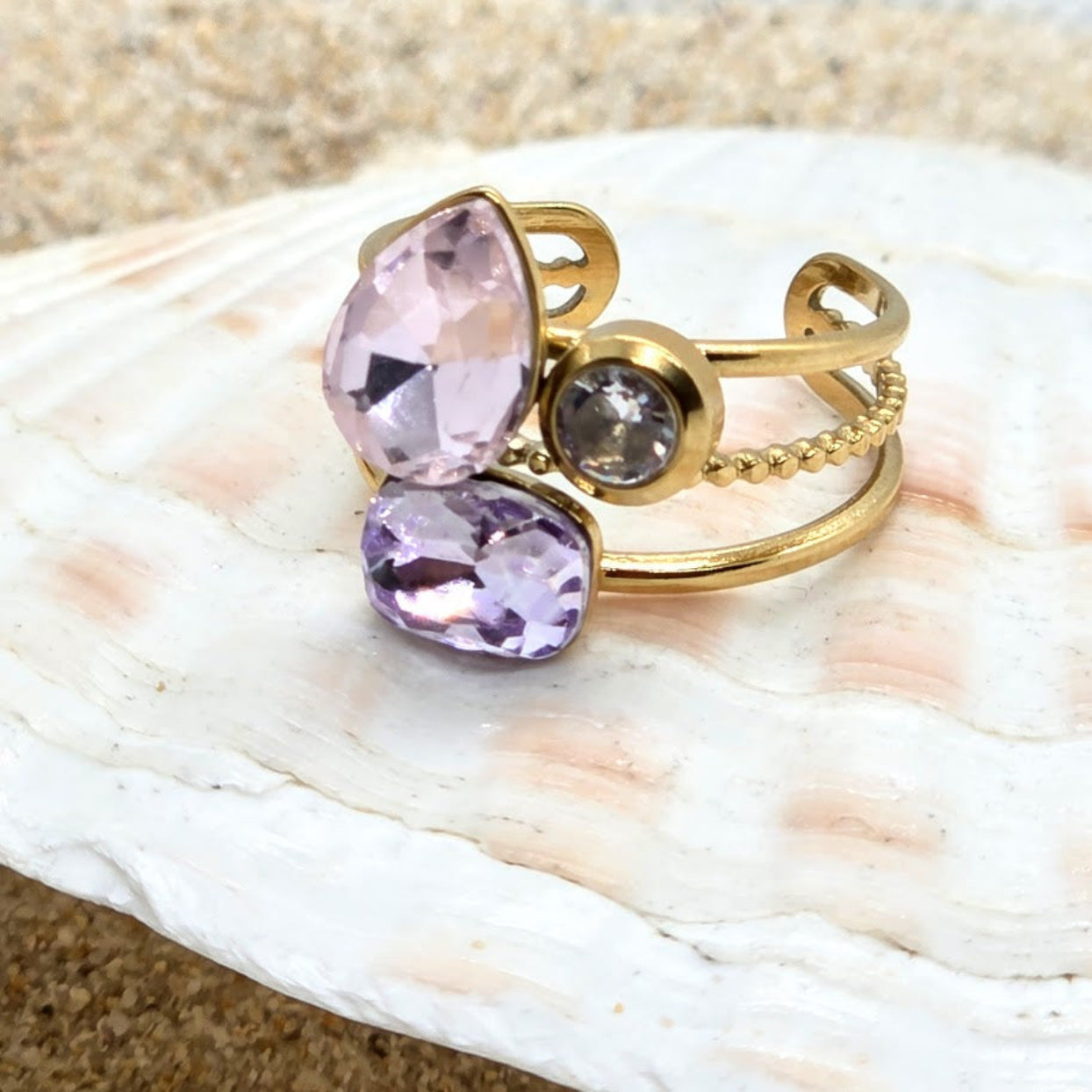 Gold rings with purple gemstones on a seashell
