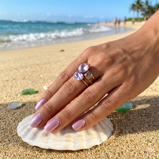 Hand with a ring on a shell at the beach