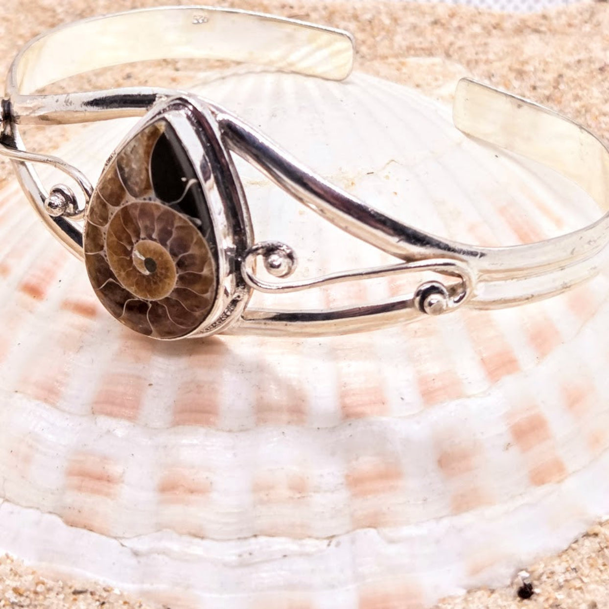 Silver bracelet with a fossilized ammonite on a seashell