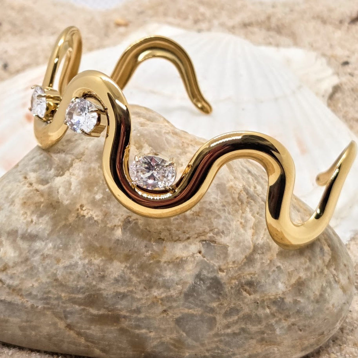 Gold bracelet with diamond accents on a stone surface