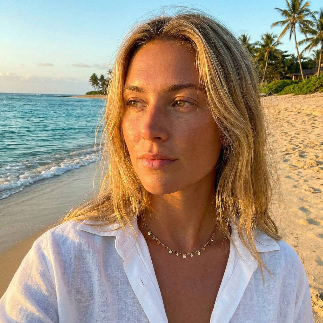 Woman on a beach with ocean and palm trees in the background