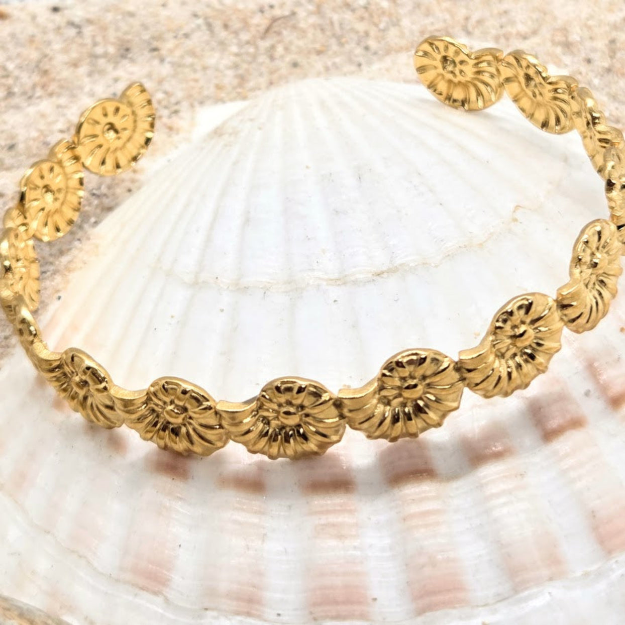Gold bracelet with floral patterns on a seashell background