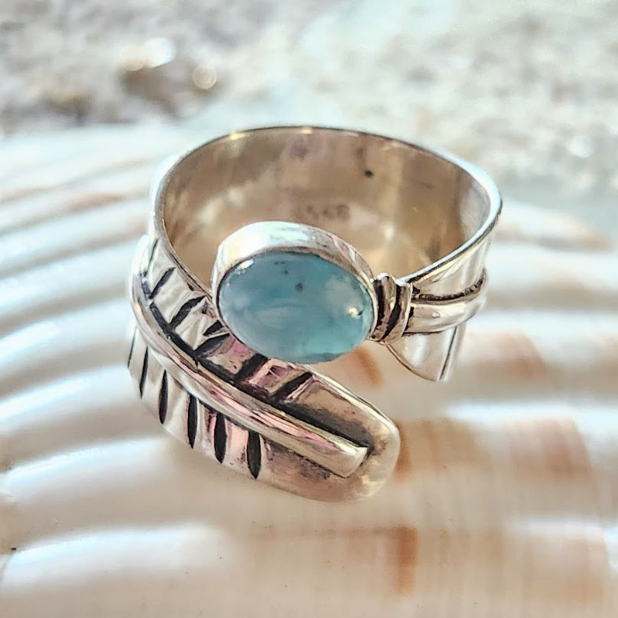 Silver ring with a blue stone on a shell background