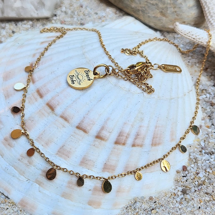 Gold necklace with charms on a seashell
