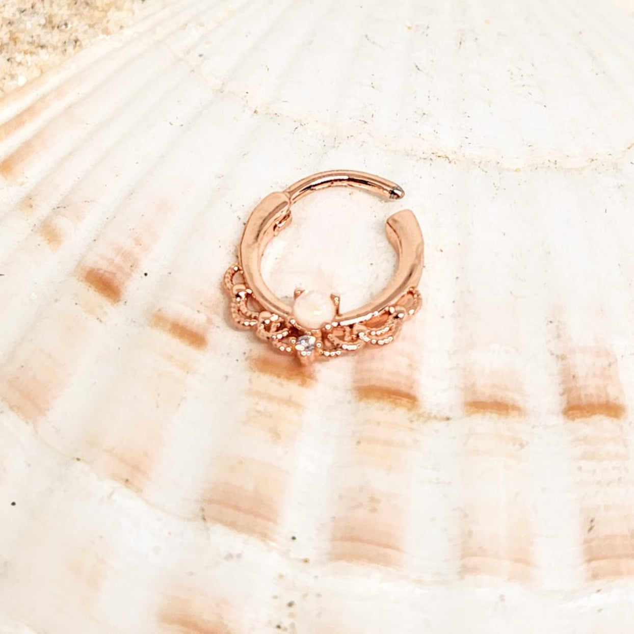 Rose gold hoop earring on a seashell