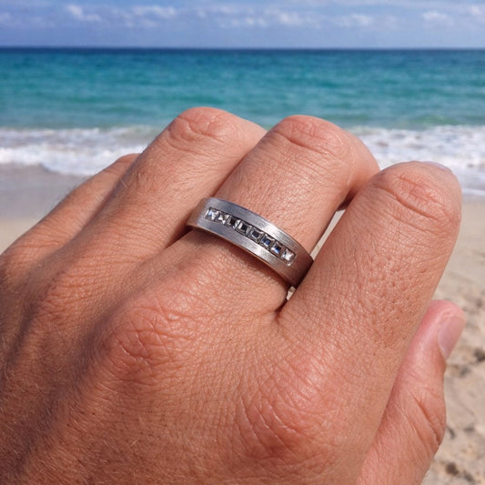 Silver ring on a hand with a beach and ocean in the background