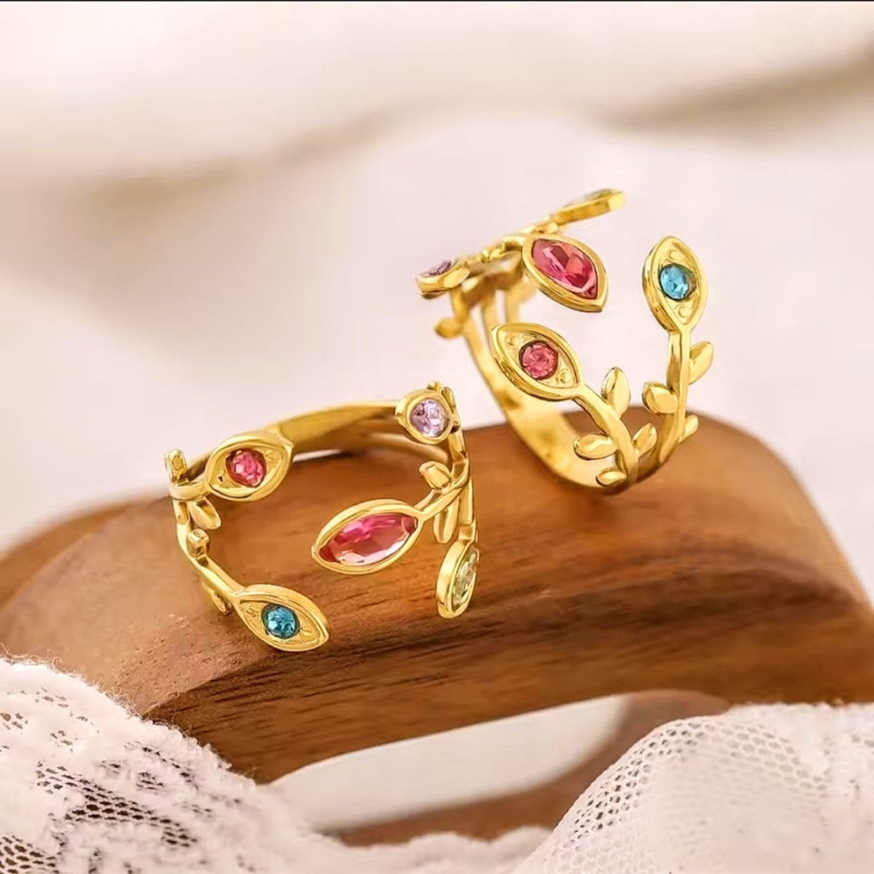 Gold earrings with gemstones on a wooden surface