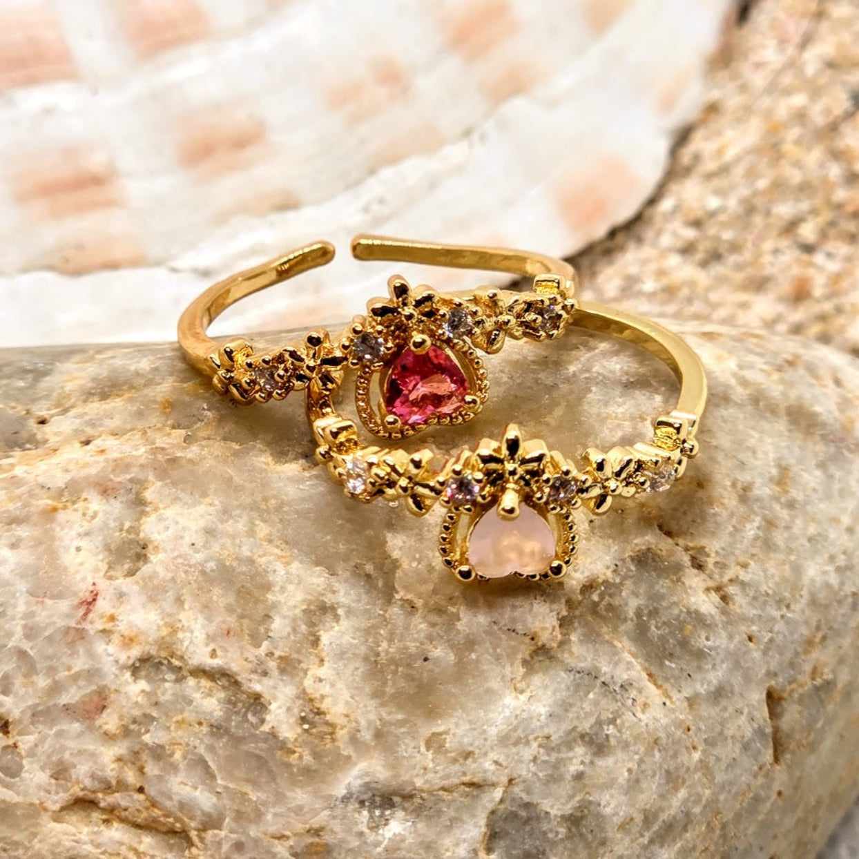 Gold rings with gemstones on a stone surface