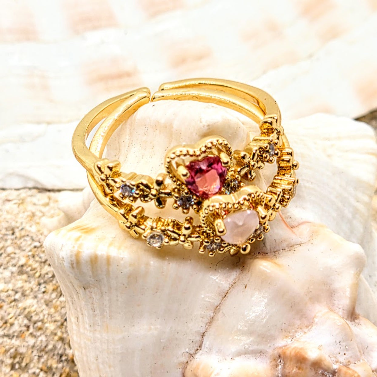 Gold ring with a red gemstone on a seashell