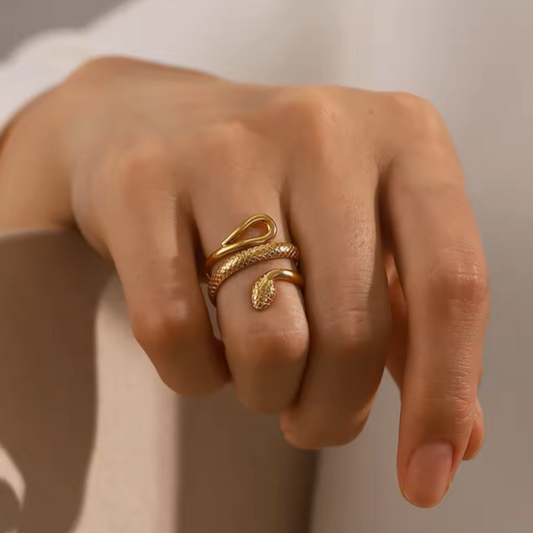 Gold ring on a person's finger against a neutral background