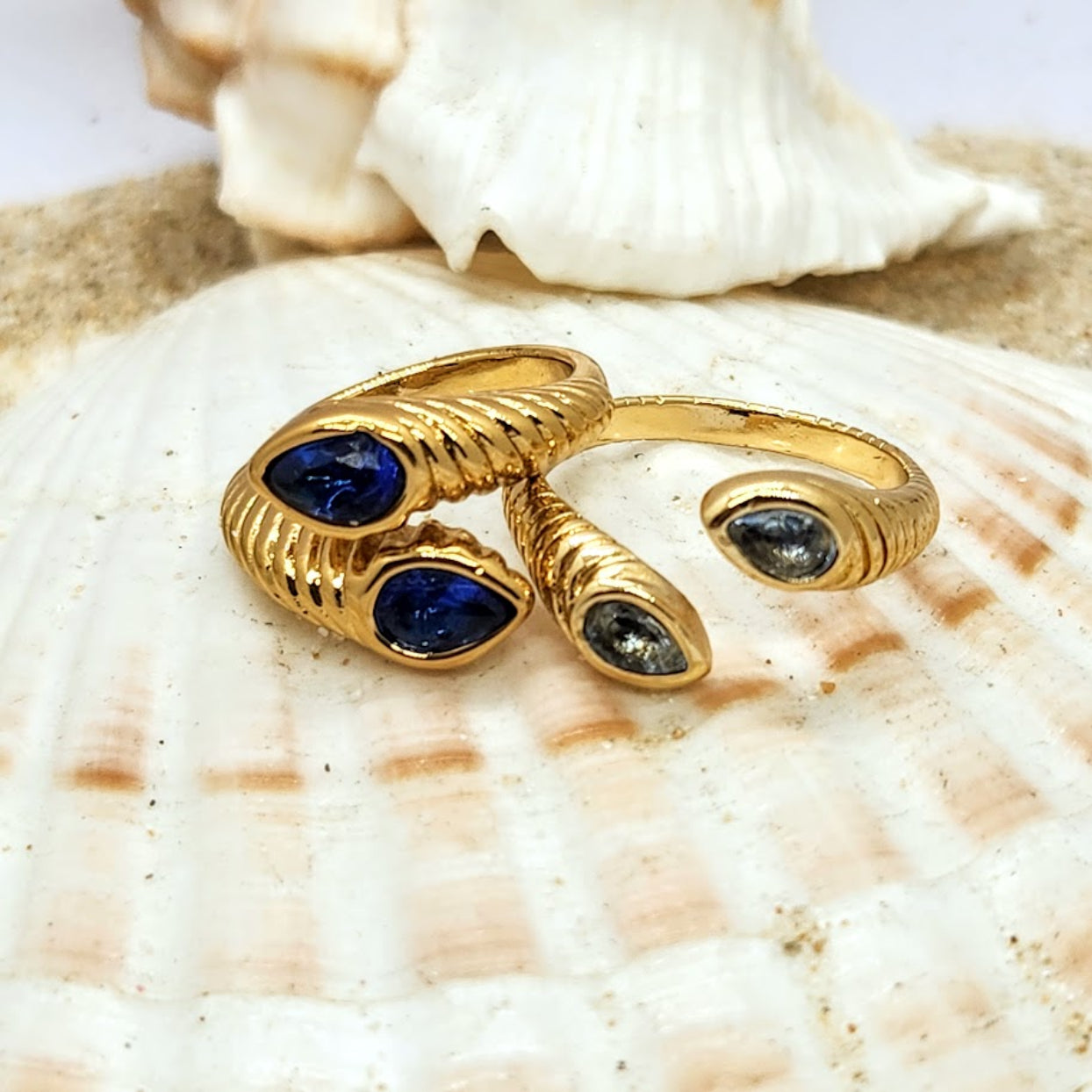 Gold rings with blue gemstones on a seashell