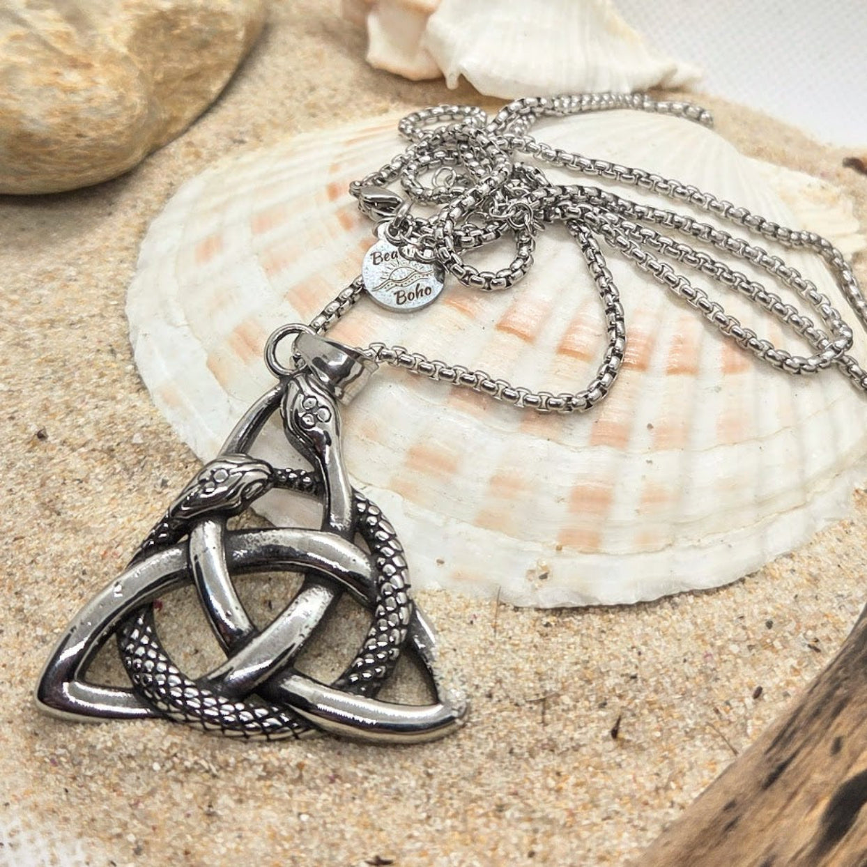 Silver necklace with a intricate pendant on a shell