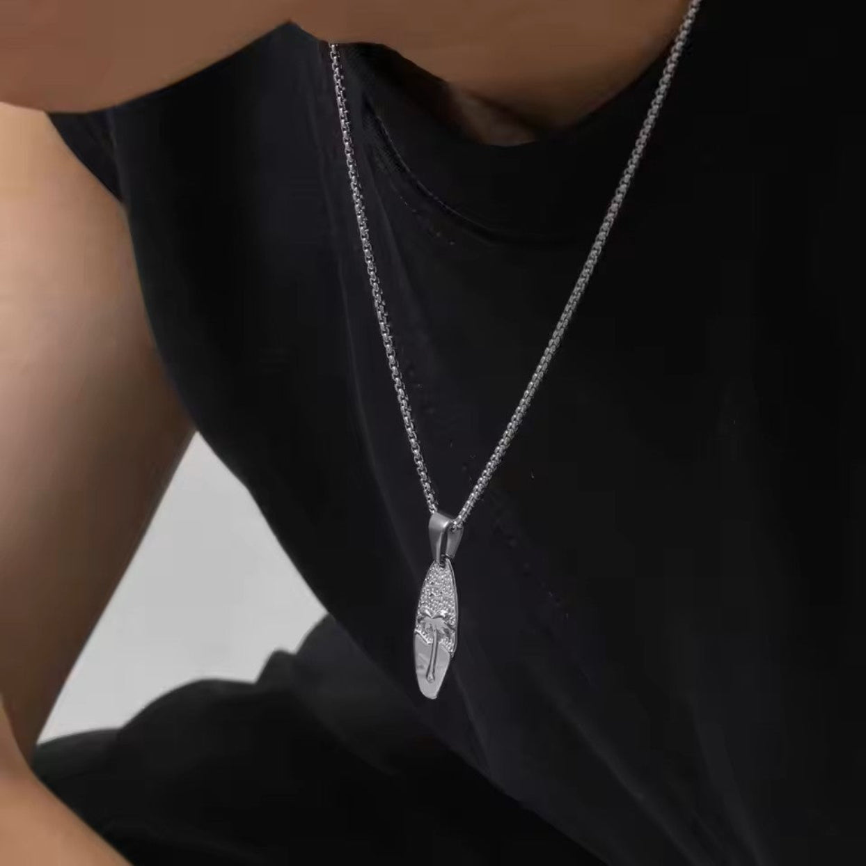 Silver necklace with a pendant on a black shirt