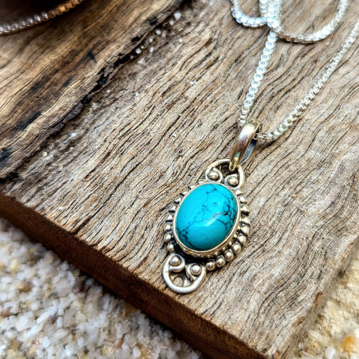 Turquoise pendant necklace on a wooden surface