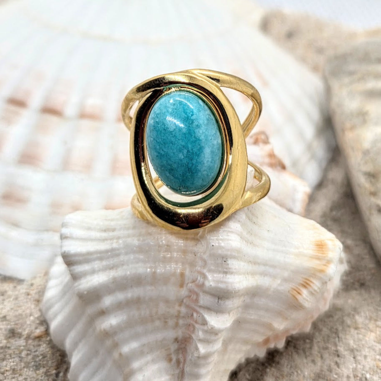 Gold ring with a blue stone on a seashell