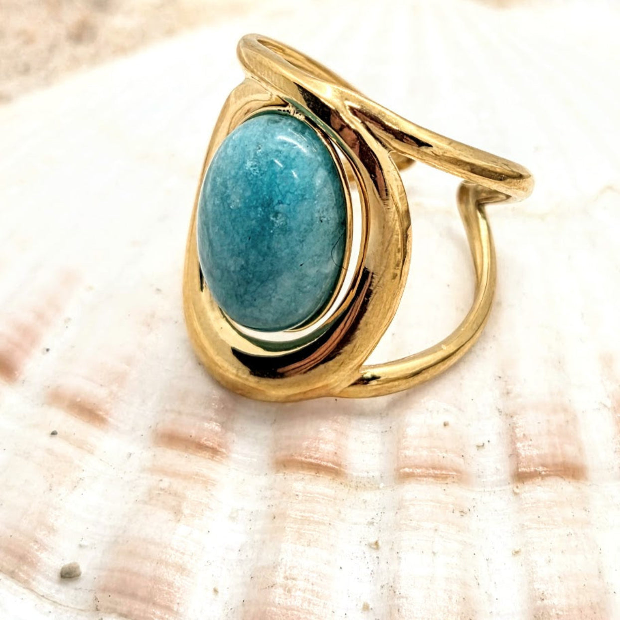 Gold ring with a turquoise stone on a seashell