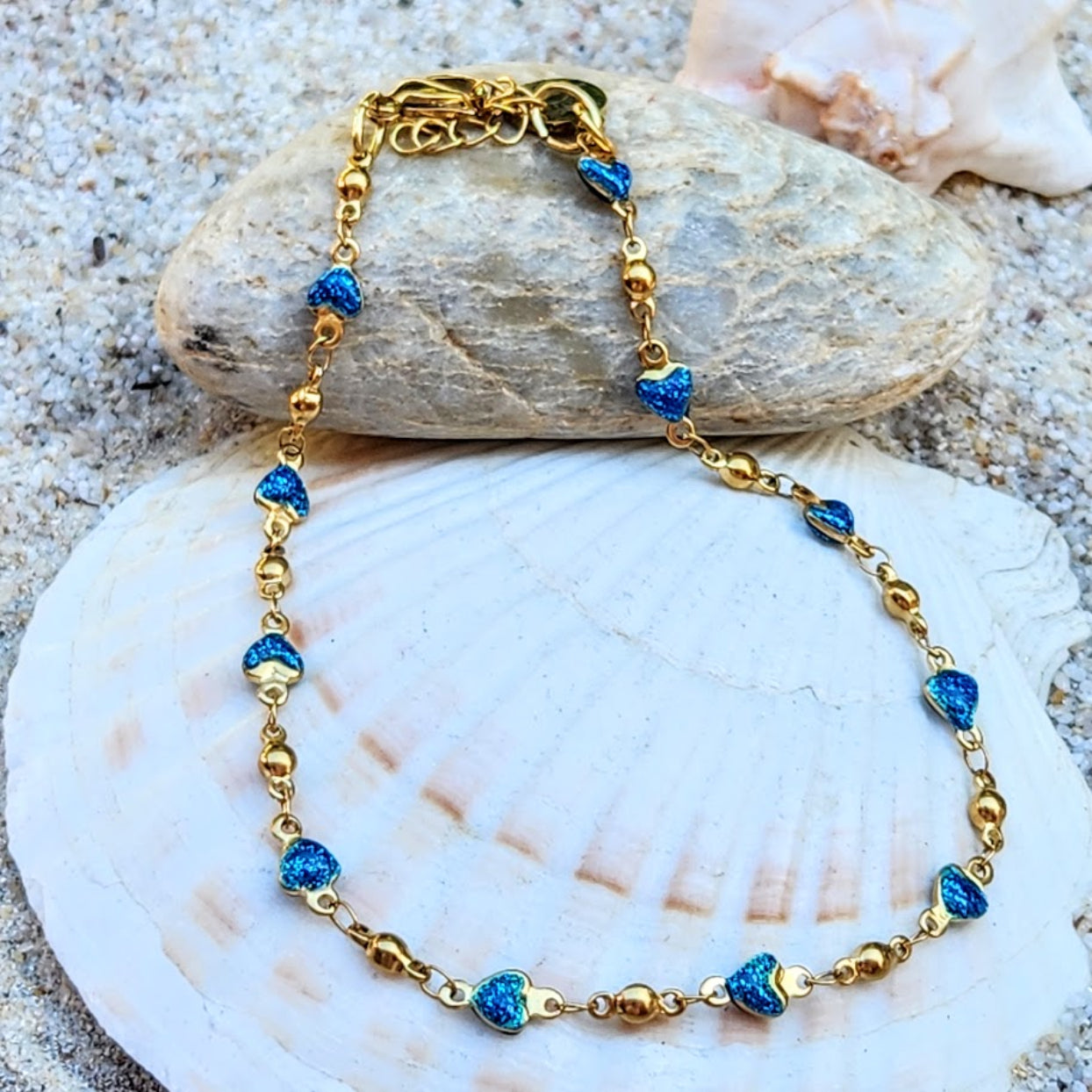Gold bracelet with blue beads on a shell