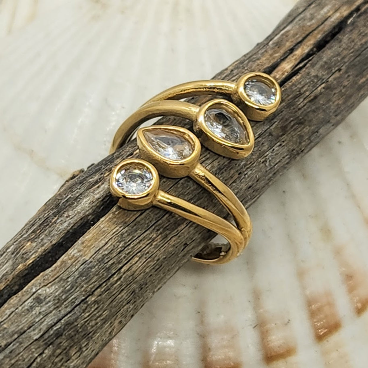 Gold ring with clear stones on a wooden surface