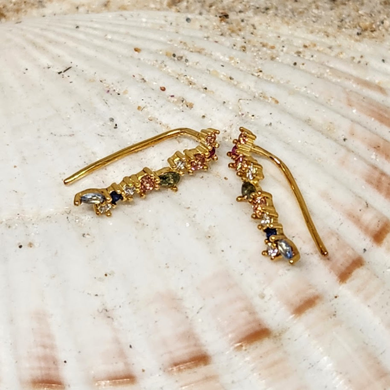 Gold earrings with gemstones on a shell