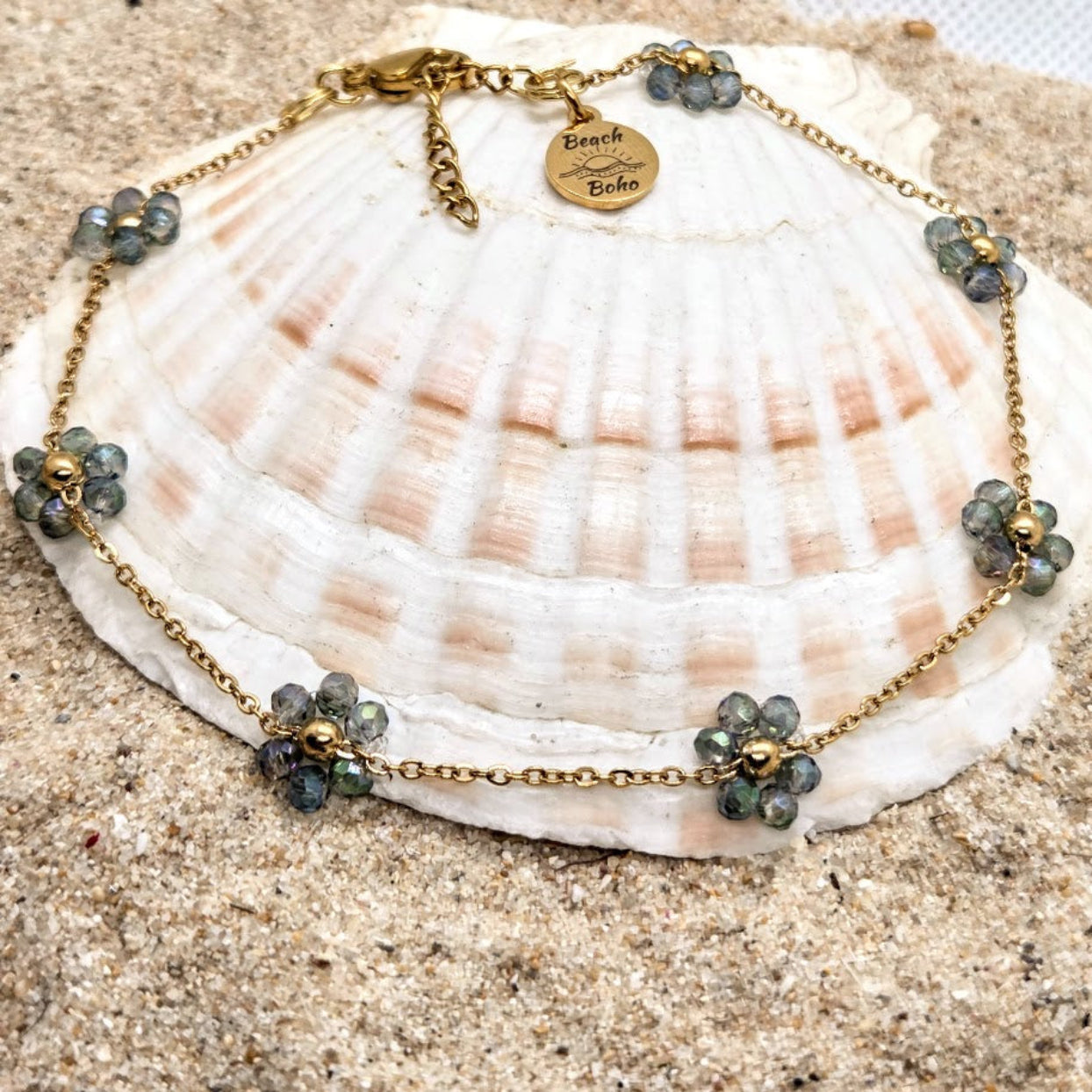 Necklace with gemstones on a seashell against a sandy background