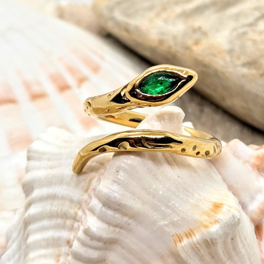 Gold ring with a green gemstone on a seashell