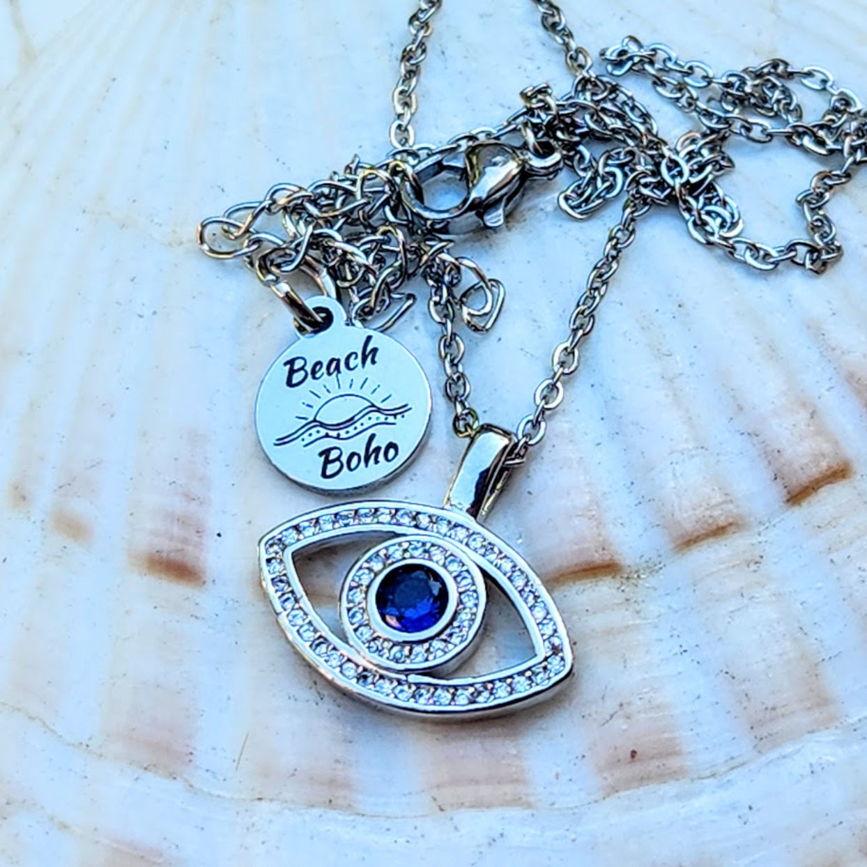 Necklace with 'Beach Boho' pendant and eye-shaped charm on a shell background