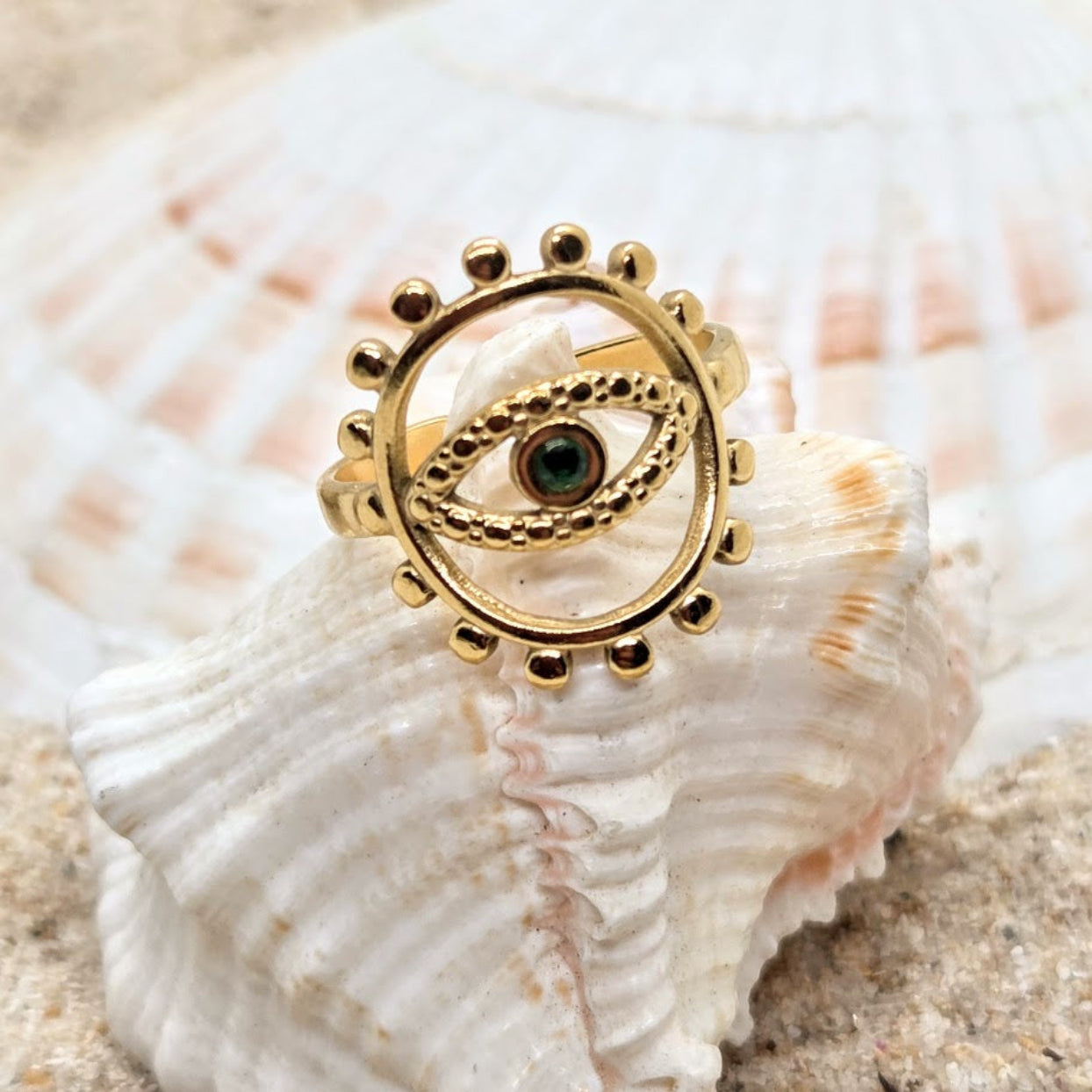 Gold ring with eye design on a seashell