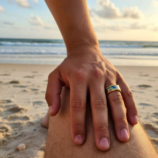 Hand with a ring on a beach at sunset