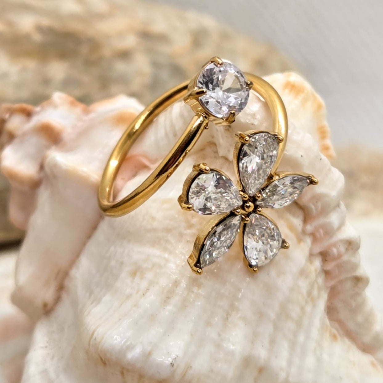 Gold ring with diamond flower design on a shell