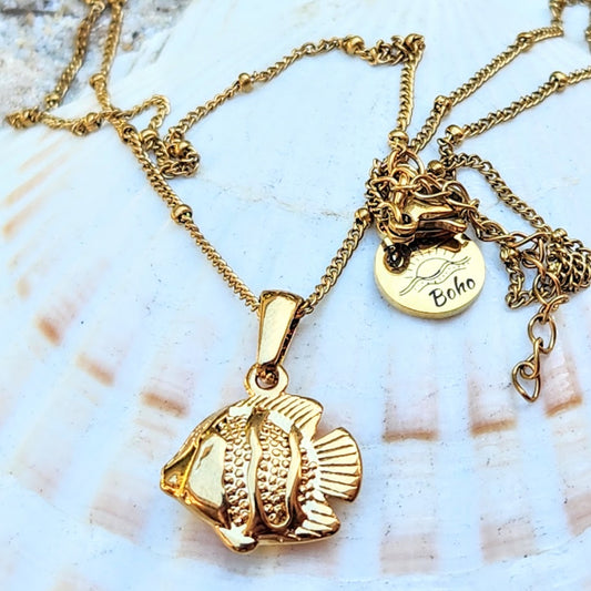 Gold fish pendant necklace with 'Boho' charm on a shell background