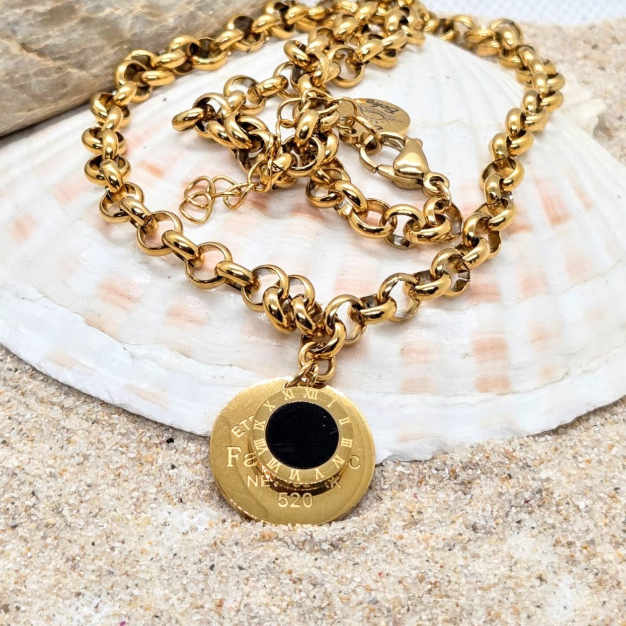 Gold chain necklace with a round pendant on a shell
