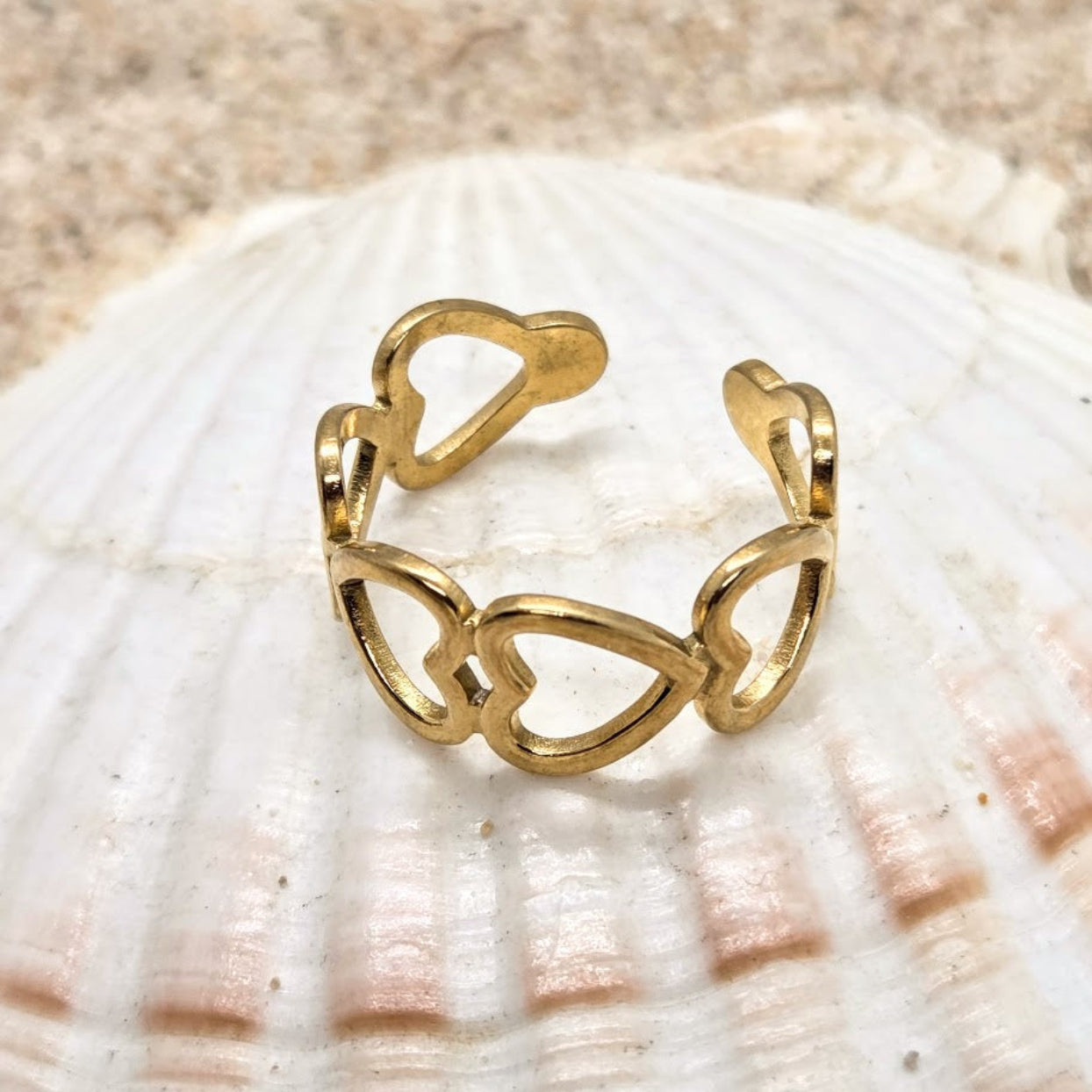 Gold ring with heart designs on a seashell