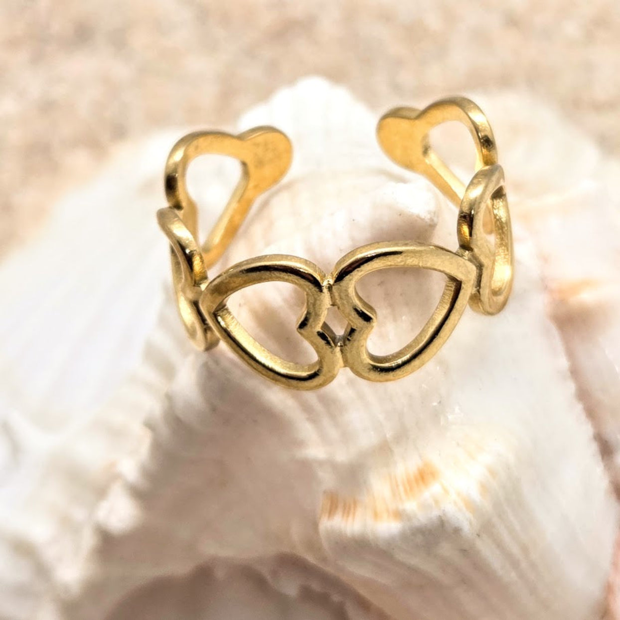 Gold heart-shaped ring on a shell background