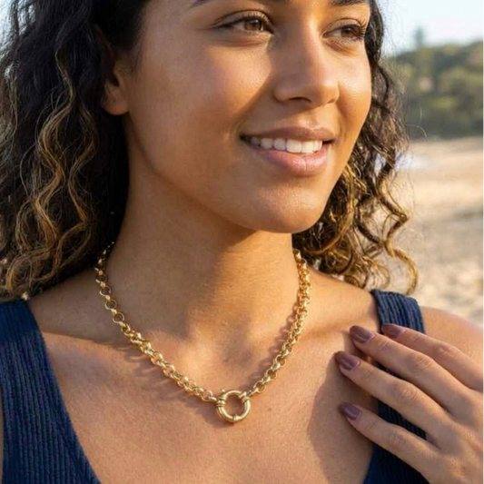 Woman wearing a gold necklace on a beach