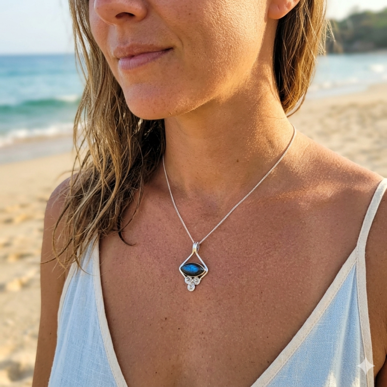 Woman wearing a necklace with a blue pendant on a beach