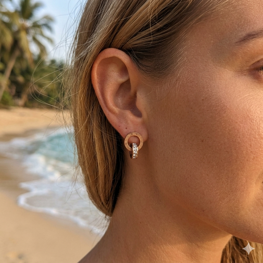 Close-up of a person's ear with an earring, beach in the background
