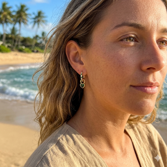 Woman with earrings on a beach with palm trees and ocean in the background