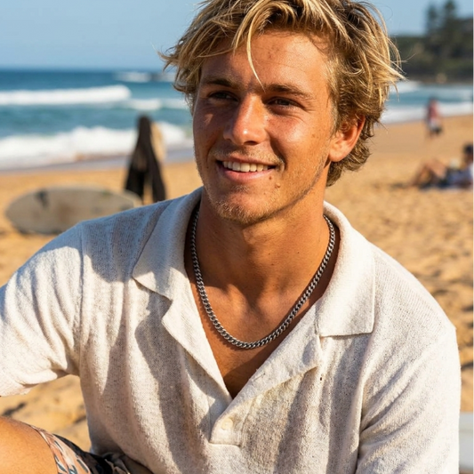 Man sitting on a beach with ocean in the background