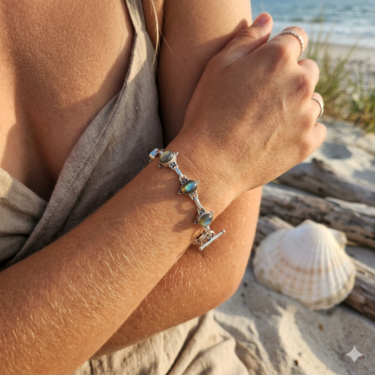 Close-up of a person's arm with a bracelet on a beach setting