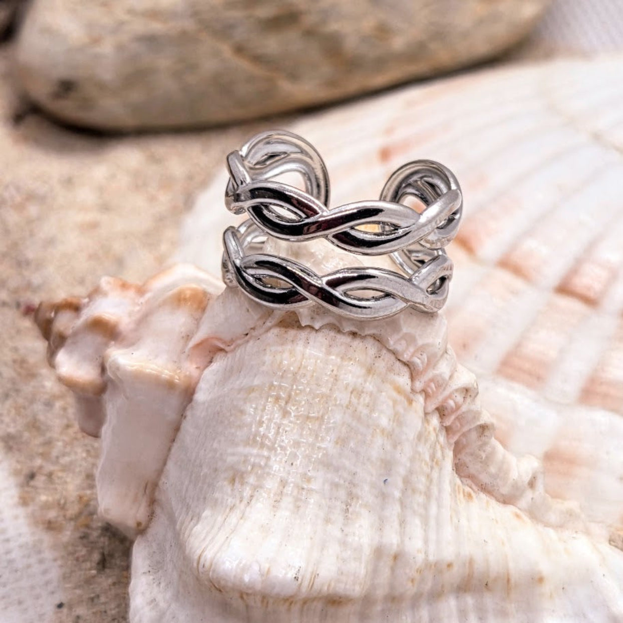 Silver ring with a twisted design on a seashell