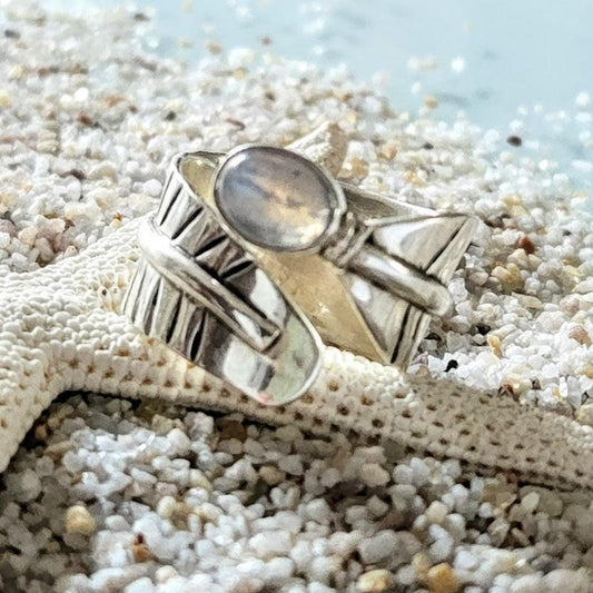 Silver ring with a stone on a starfish on sandy beach