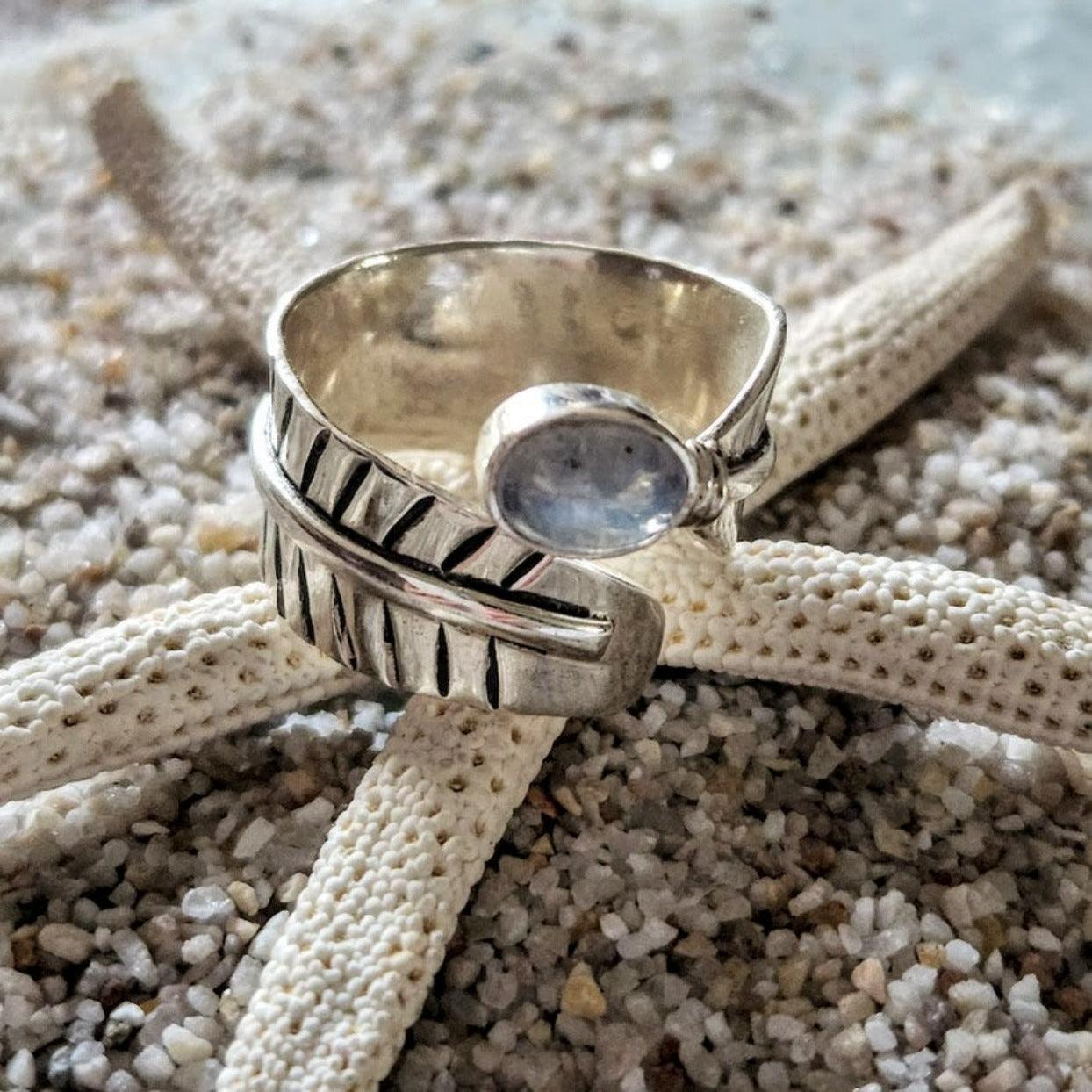 Silver ring with a stone on a starfish on sand