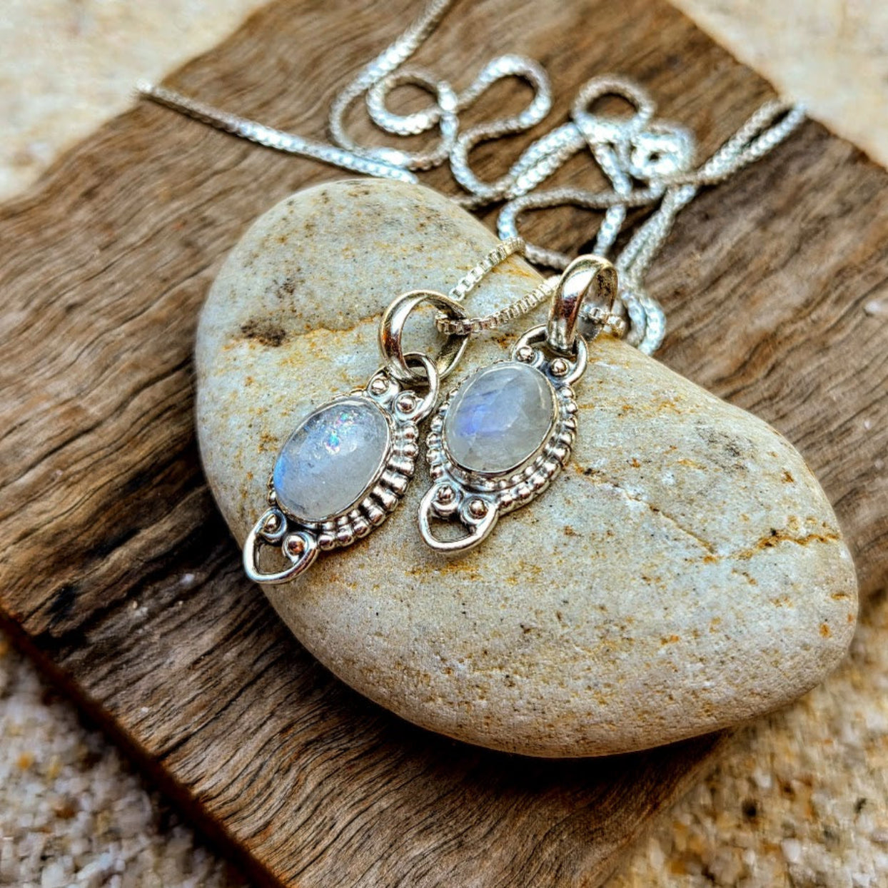 Silver necklace with pendant on a stone surface