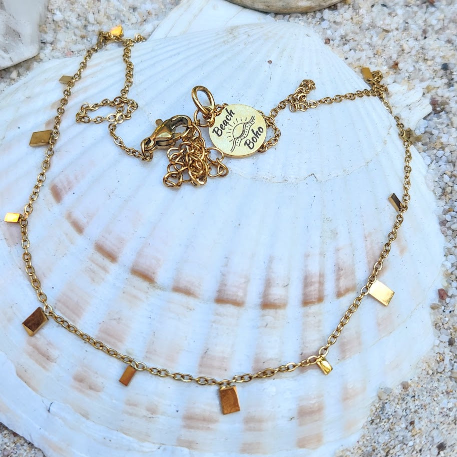 Gold bracelet with charms on a seashell