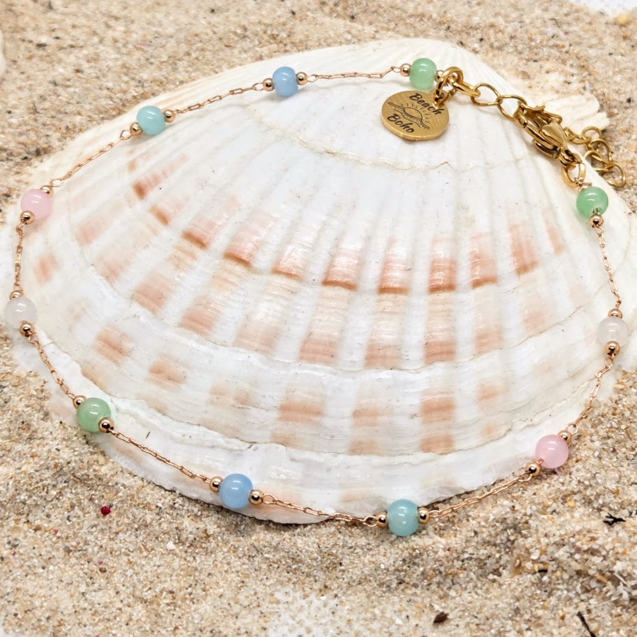 Bracelet with beads on a seashell on sand
