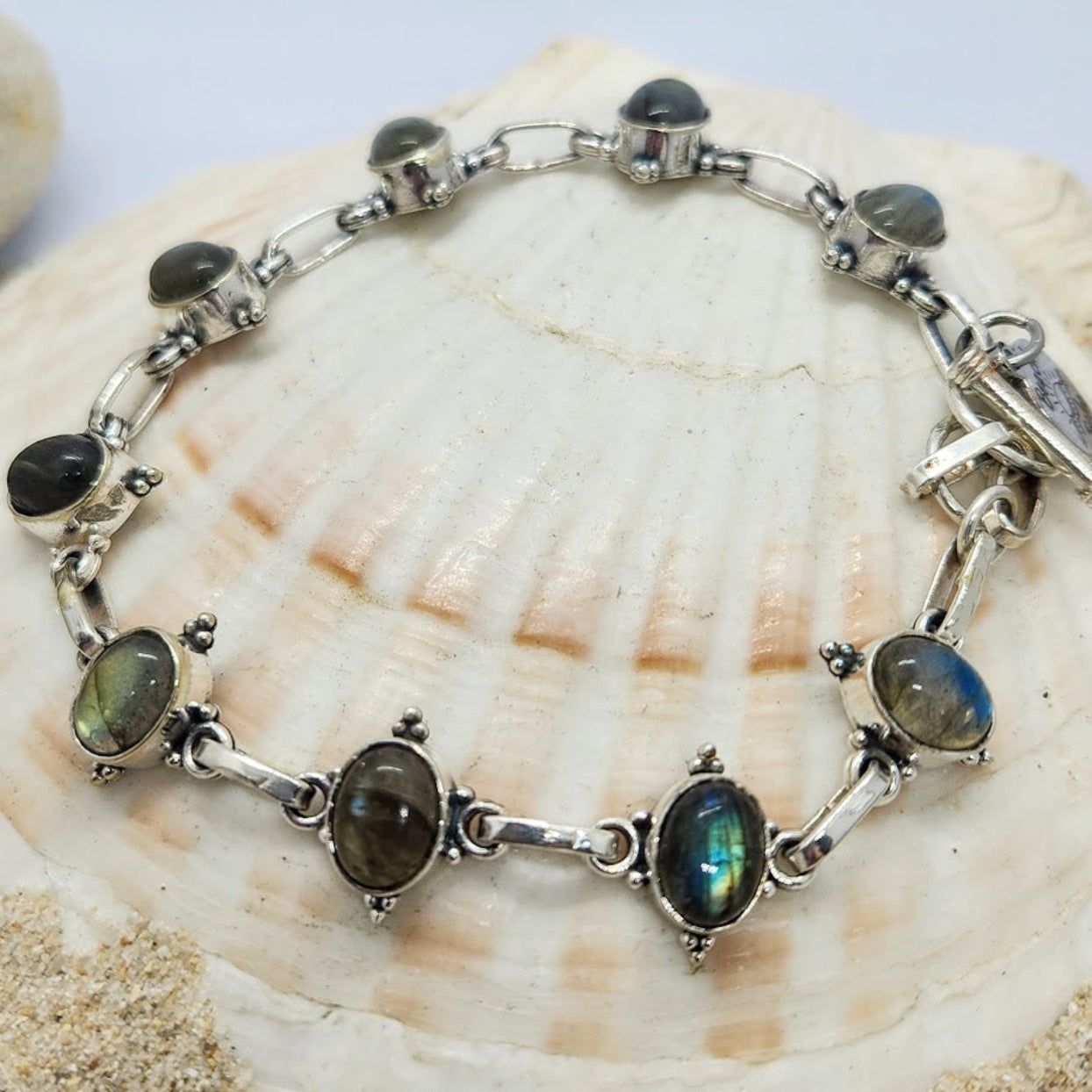 Silver bracelet with gemstones on a shell